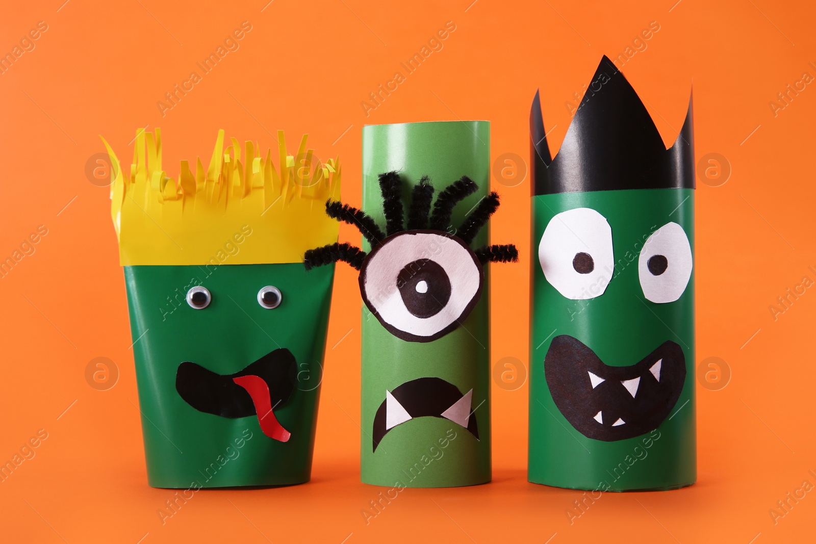 Photo of Funny monsters on orange background. Halloween decoration