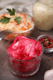 Photo of Delicious sauerkraut prepared according to different recipes on brown table, closeup view