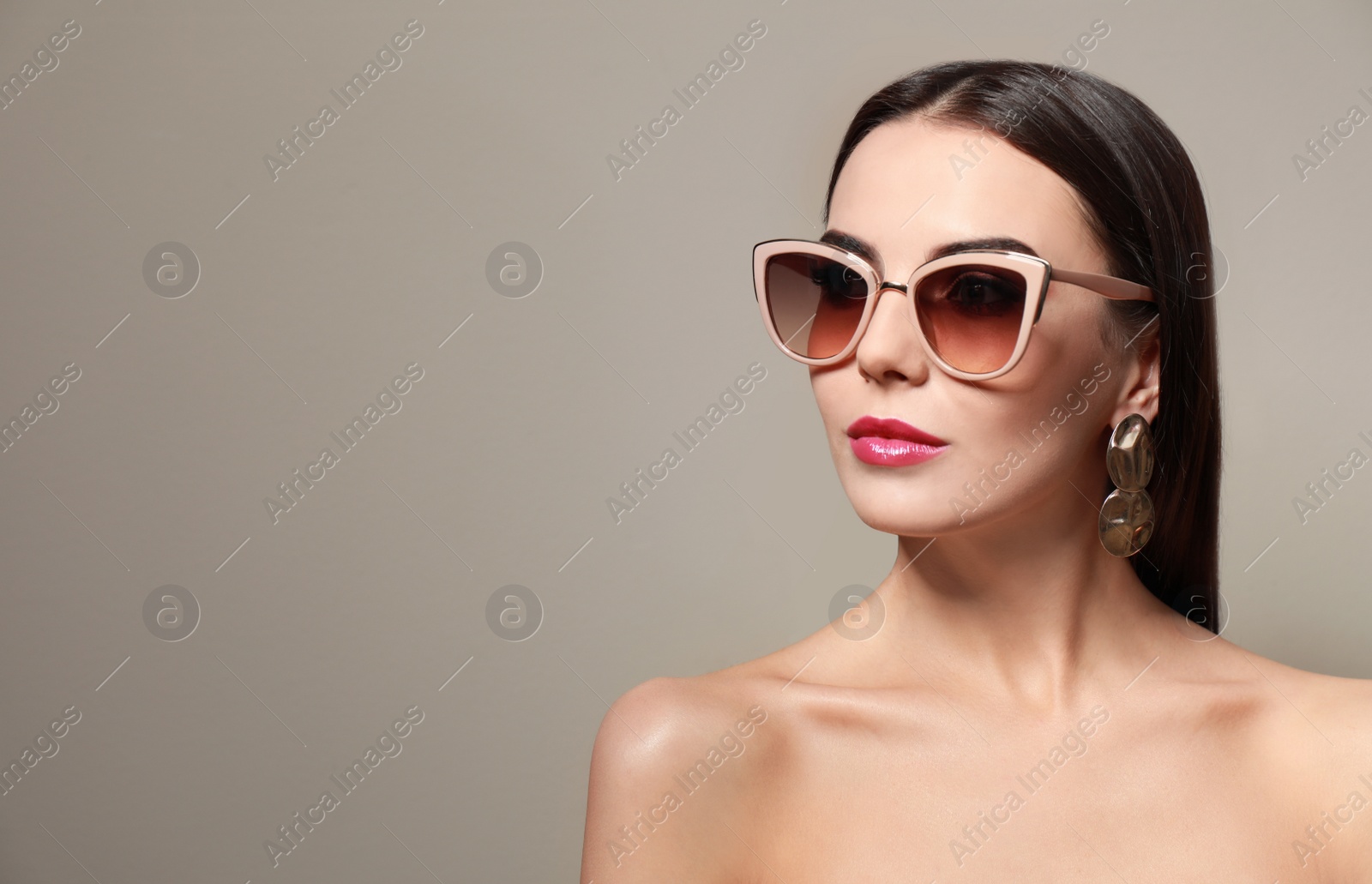 Photo of Beautiful woman in stylish sunglasses on beige background. Space for text