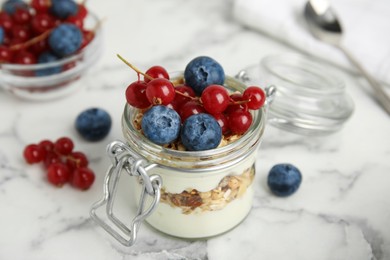 Photo of Delicious yogurt parfait with fresh berries on white marble table, closeup
