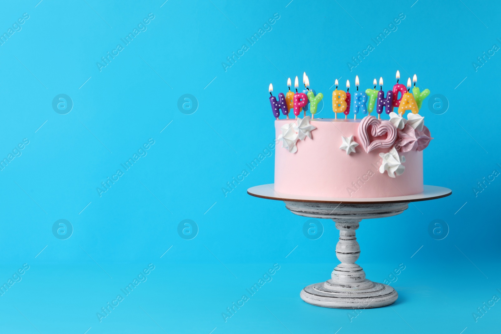 Photo of Birthday cake with burning candles on light blue background, space for text