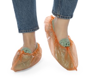 Woman wearing shoe covers onto her mules against white background, closeup