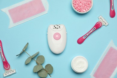 Flat lay composition with epilator and other hair removal products on light blue background
