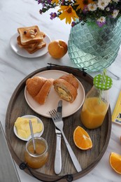 Photo of Tray with tasty breakfast on white table in morning, above view