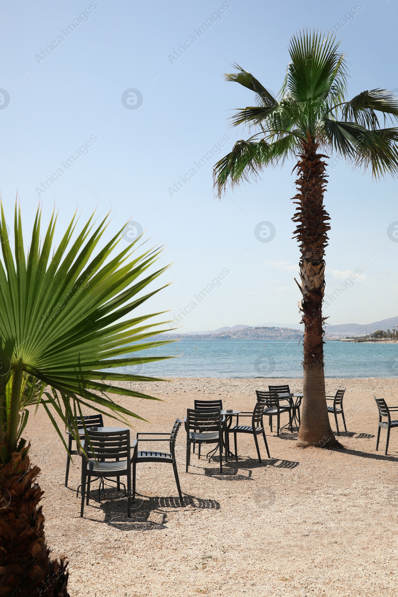 Photo of Beautiful view of chairs and tables on sandy beach near sea