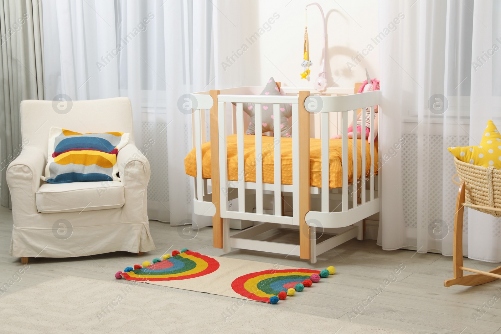 Photo of Cozy baby room with crib and other furniture. Interior design