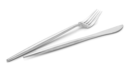 Photo of Shiny silver fork and knife isolated on white. Luxury cutlery