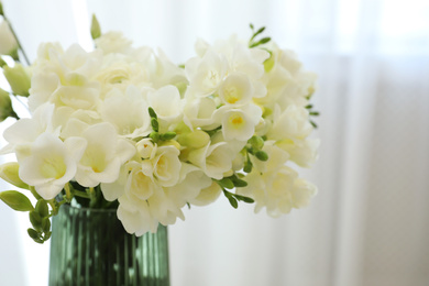 Beautiful bouquet with white freesia flowers in vase indoors, closeup