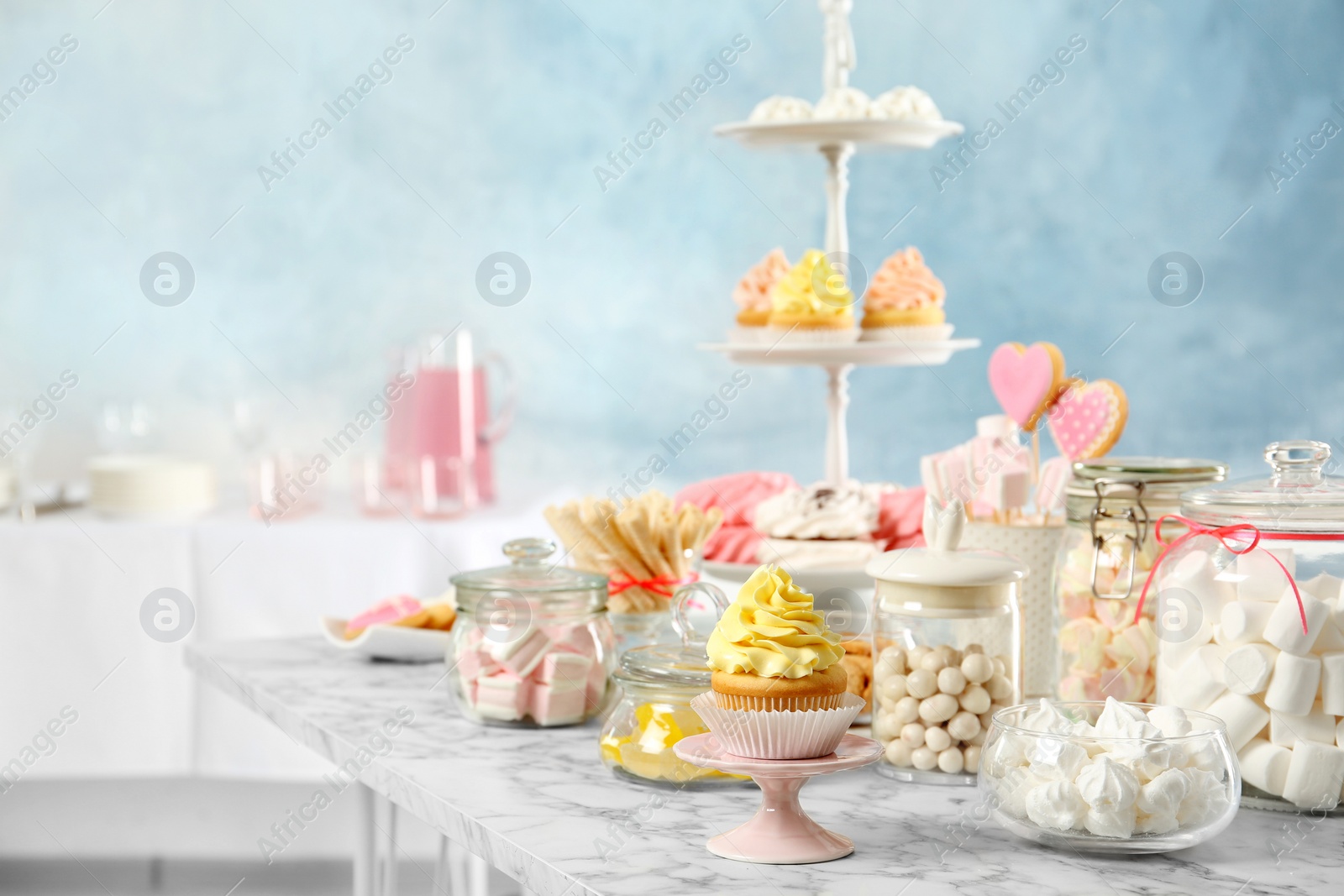 Photo of Candy bar with different sweets on white marble table indoors. Space for text