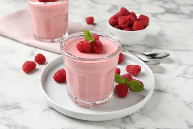 Photo of Delicious raspberry mousse with mint on white marble table