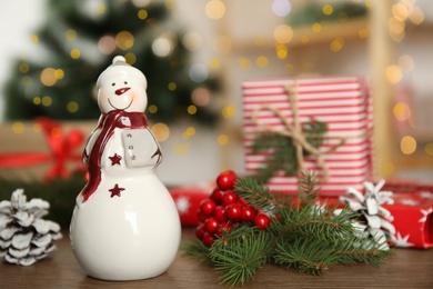 Photo of Christmas composition with decorative snowman on wooden table, space for text
