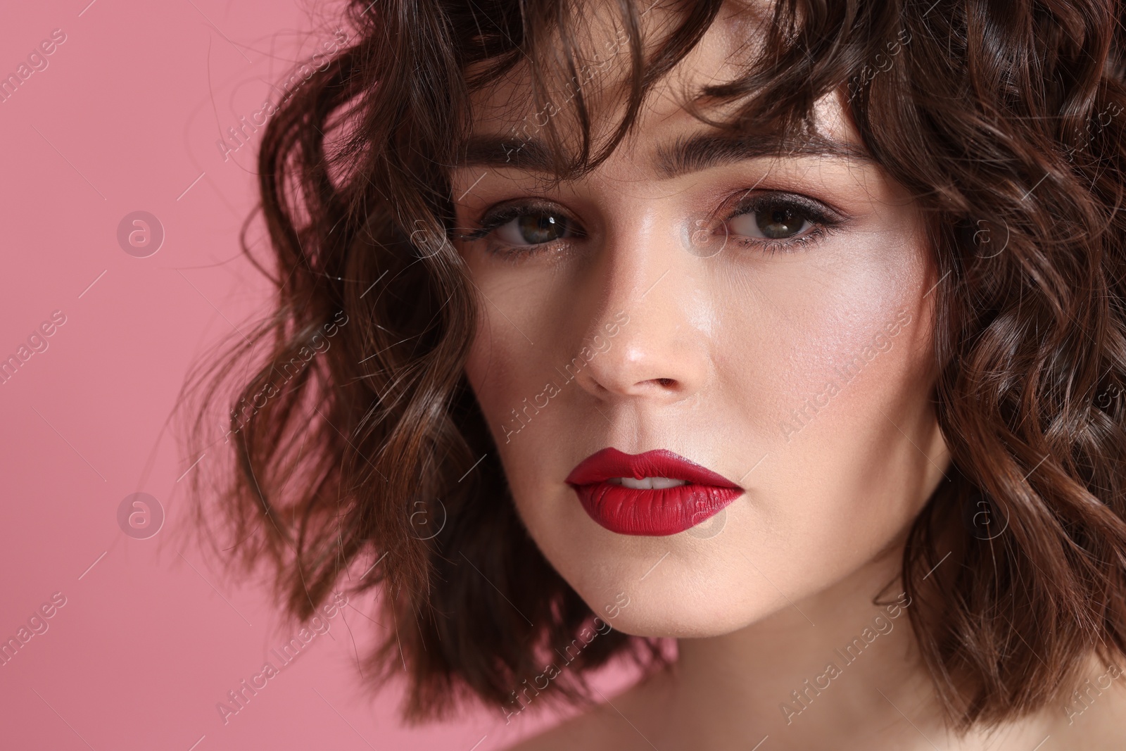 Photo of Beautiful young woman with wavy hairstyle on pink background