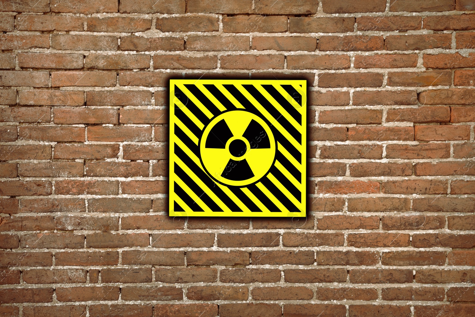 Image of Radioactive sign on brick wall. Hazard symbol