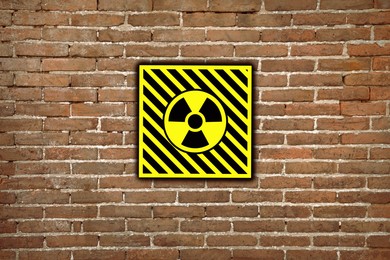 Image of Radioactive sign on brick wall. Hazard symbol