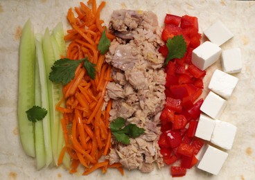 Photo of Delicious tortilla with tuna and vegetables, top view. Cooking shawarma