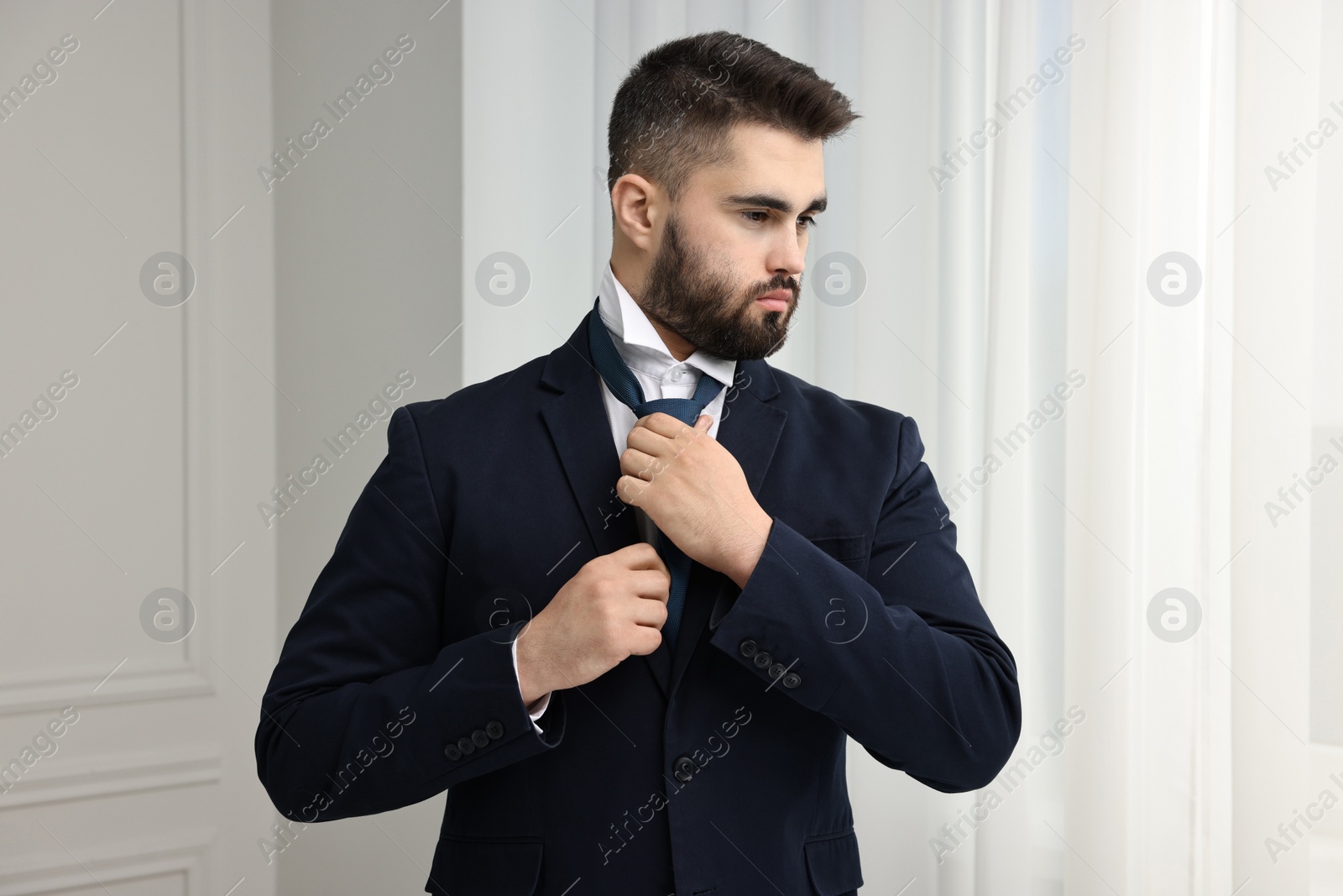 Photo of Handsome businessman in suit and necktie indoors