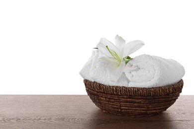 Fresh towels and lily flower on wooden table against white background. Space for text