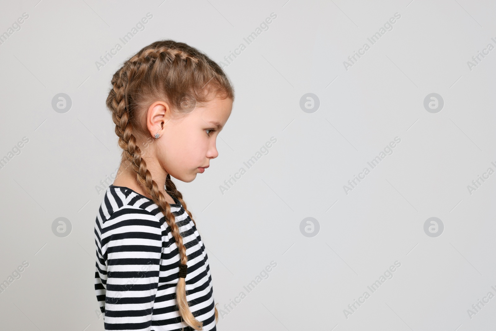 Photo of Little girl on light grey background, space for text. Children's bullying