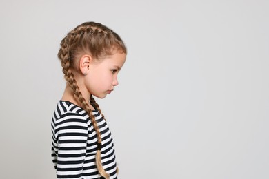 Little girl on light grey background, space for text. Children's bullying