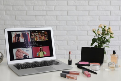 Photo of Laptop with open fashion blogger site on table. Space for text