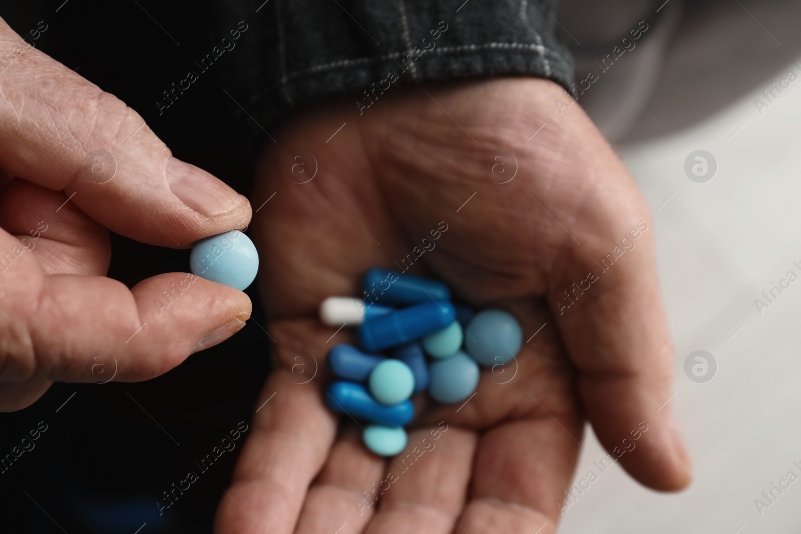Photo of Senior man taking pills, closeup of hands