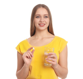 Young woman with vitamin pill and glass of water on white background