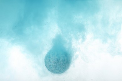 Photo of Light blue bath bomb dissolving in water