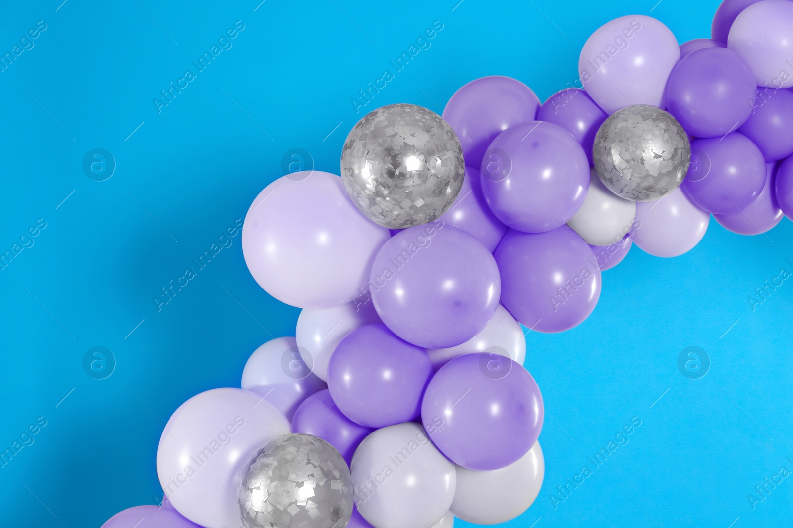 Image of Balloon garland on light blue background. Festive decor