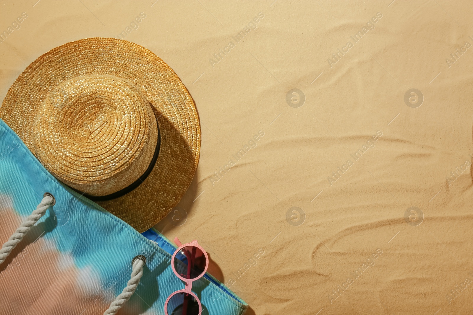 Photo of Beach accessories on sand, top view. Space for text
