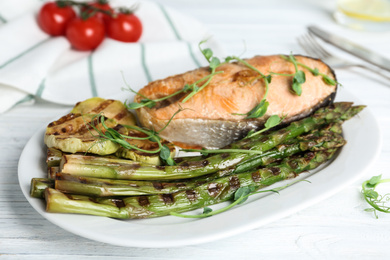 Tasty salmon steak served with grilled asparagus on plate