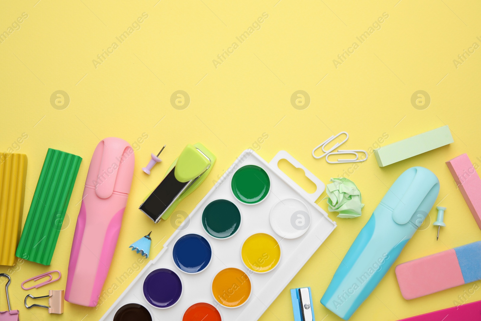 Photo of Flat lay composition with different school stationery on pale yellow background, space for text. Back to school