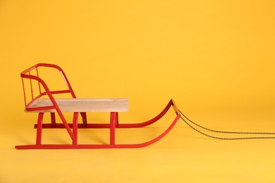 Photo of Stylish sleigh on yellow background. Space for text