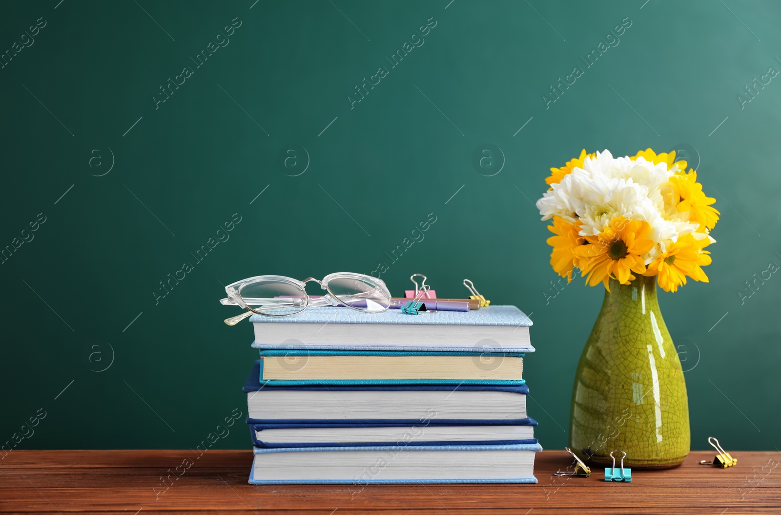 Photo of Bouquet of flowers and notebooks with eyeglasses on table. Teacher day celebration