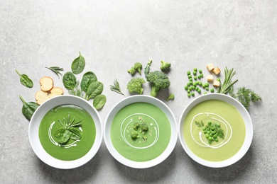 Photo of Dishes with different fresh vegetable detox soups made of green peas, broccoli, spinach and ingredients on table, flat lay