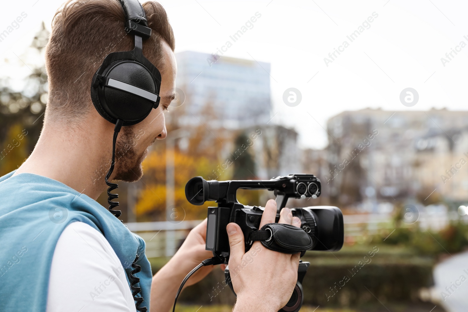 Photo of Video operator with professional camera working outdoors