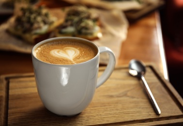 Photo of Cup of delicious coffee on wooden table