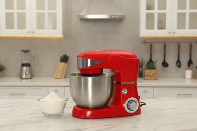 Photo of Modern red stand mixer and bowl with flour on white marble table in kitchen