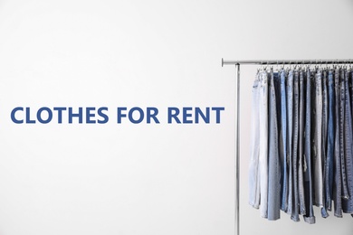 Image of Rack with different jeans for rent on light background