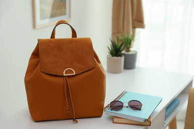 Photo of Stylish urban backpack on white table in room