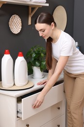 Beautiful woman opening drawer in laundry room