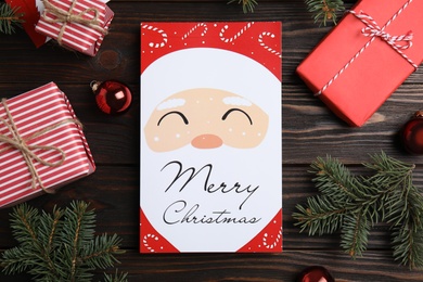 Photo of Flat lay composition with Christmas card and festive decor on wooden background