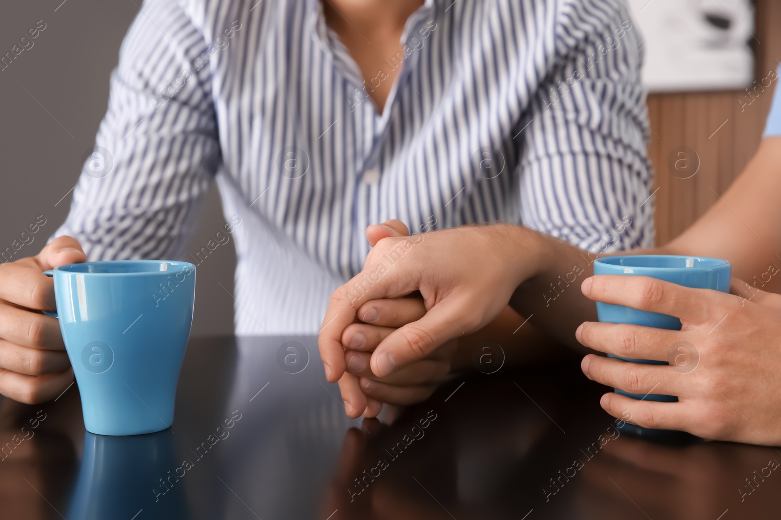 Photo of Happy gay couple with coffee at table indoors, closeup