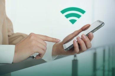 Image of Woman using smartphone connected to WiFi indoors, closeup