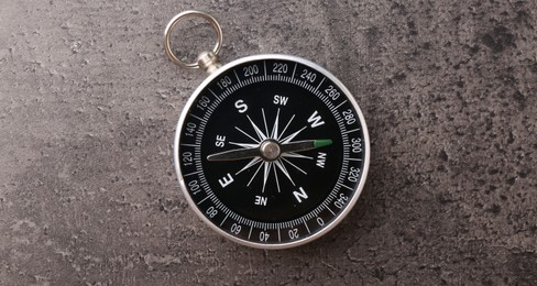 Photo of One compass on grey table, top view