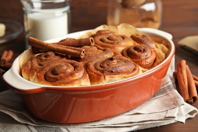 Baking dish with cinnamon rolls on table