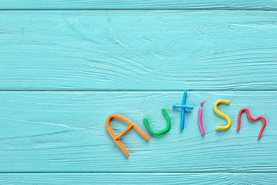 Word "Autism" made of plasticine on color wooden background