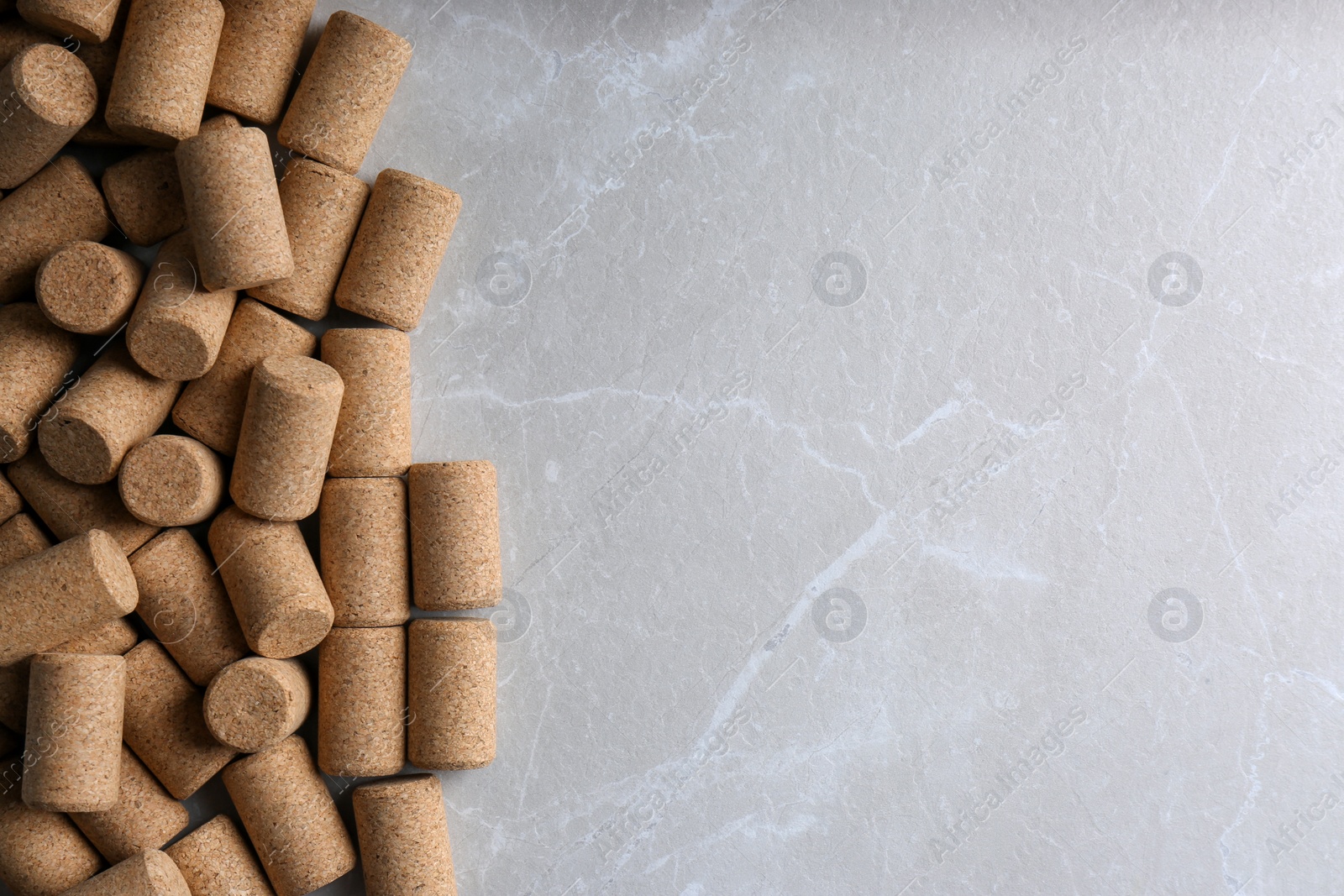 Photo of Wine bottle corks on light grey marble table, flat lay. Space for text