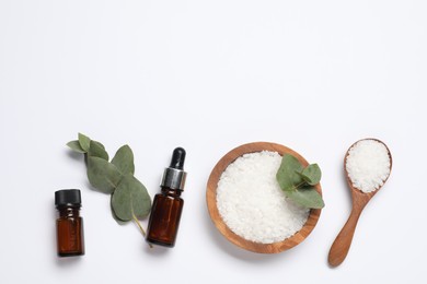 Photo of Aromatherapy products. Bottles of essential oil, sea salt and eucalyptus leaves on white background, flat lay