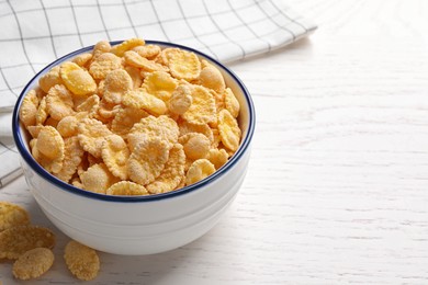 Photo of Bowl of tasty corn flakes on white wooden table. Space for text