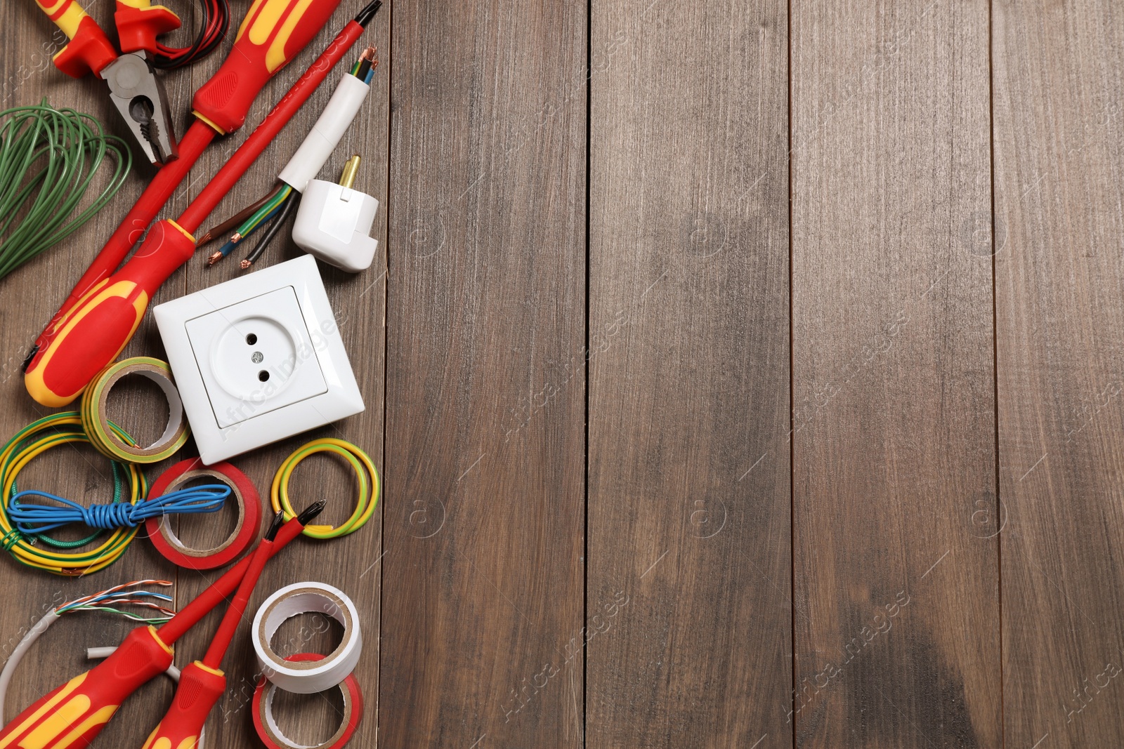 Photo of Set of electrician's tools and accessories on wooden table, flat lay. Space for text